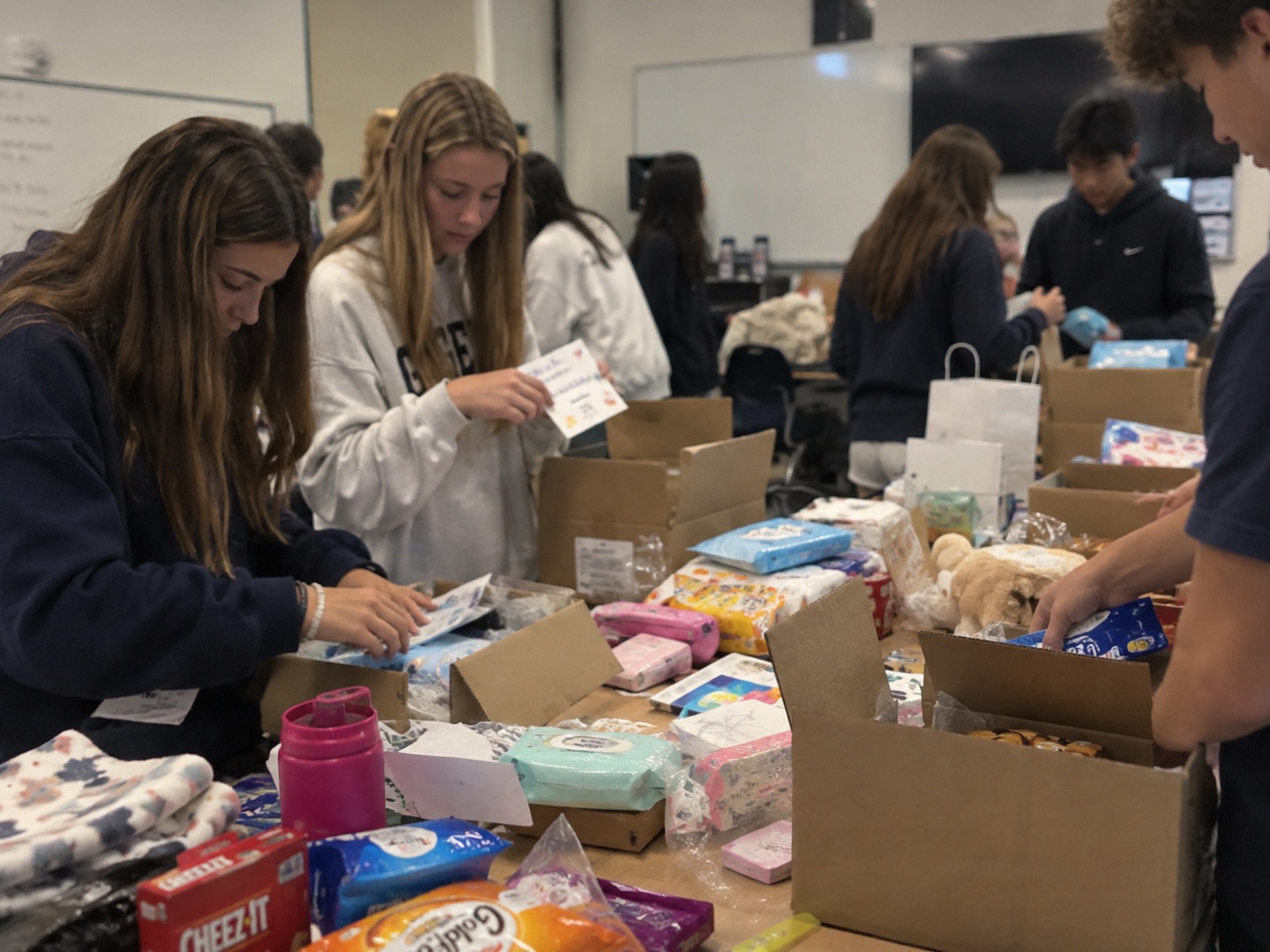 Detailing for MCAS volunteers packing hospital care packages with blankets, snacks and handwritten notes